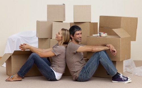 Loading boxes and furniture into a van near Canary Wharf apartment buildings